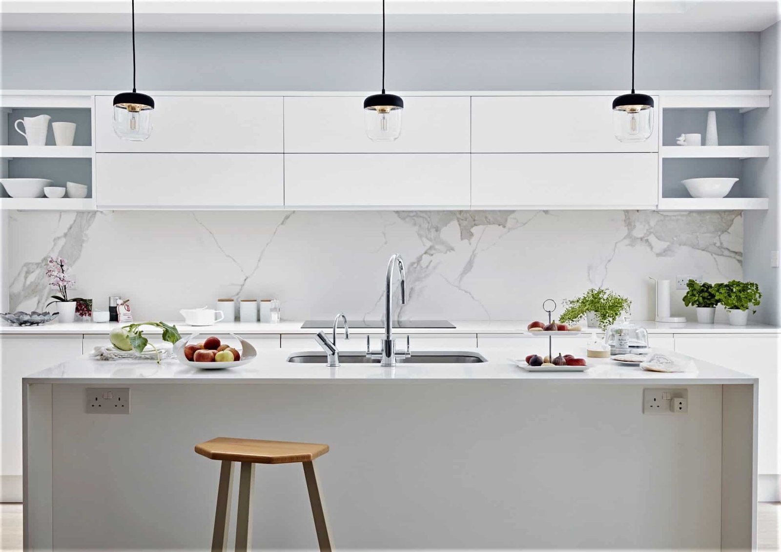 A finished modern white kitchen with a marble island